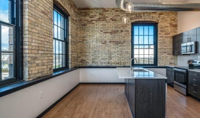 a kitchen with brick walls