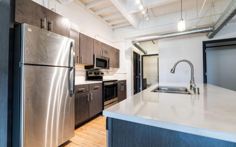a kitchen with a stainless steel refrigerator